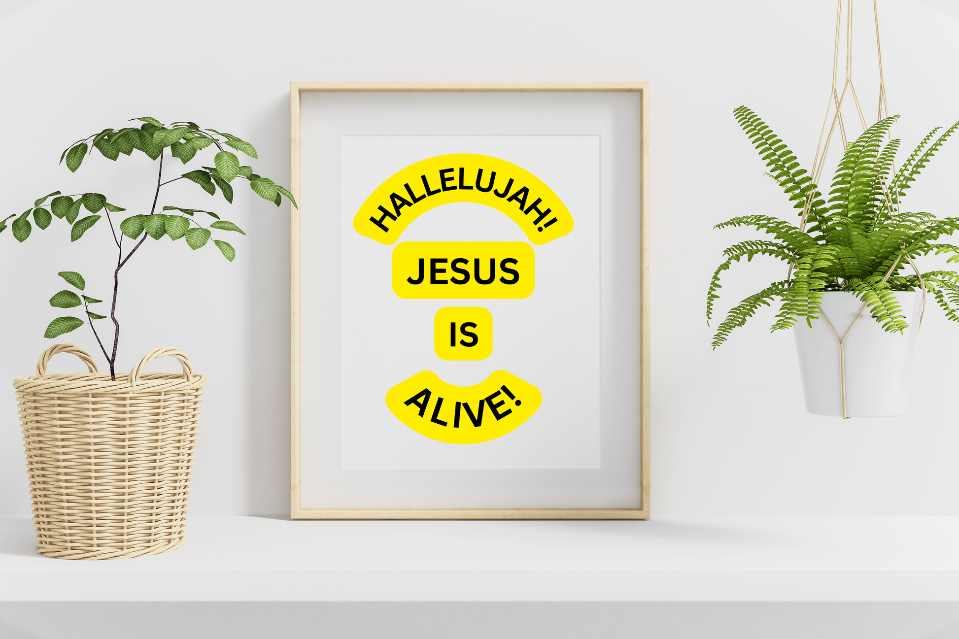 Framed print with 'Hallelujah! Jesus is Alive!' text on a white wall with plants.