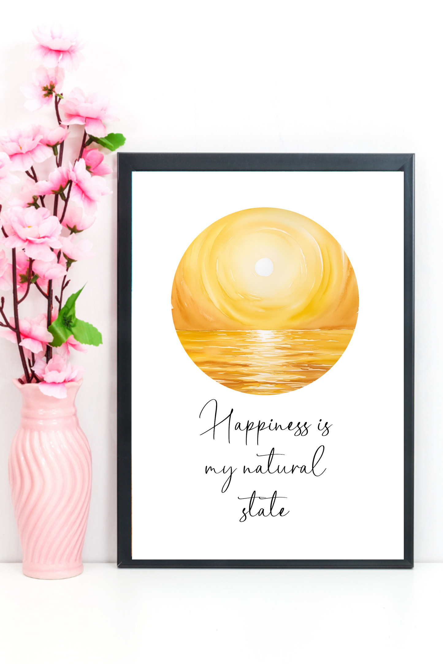 Positive quote wall print reading “Happiness Is My Natural State” framed on a modern home office wall next to pink orchids in a vase.