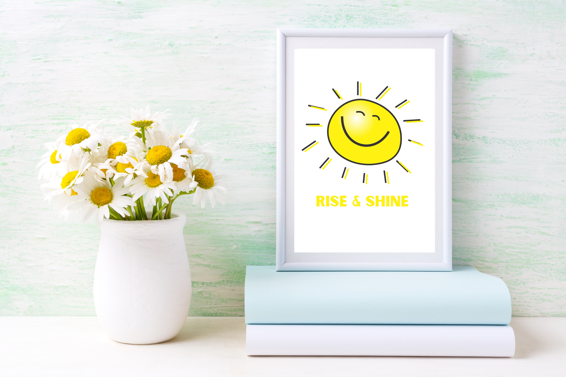 The Rise and Shine printable wall art, featuring a cheerful sun design and motivational typography, placed above a desk to create a bright, encouraging and focused work environment.