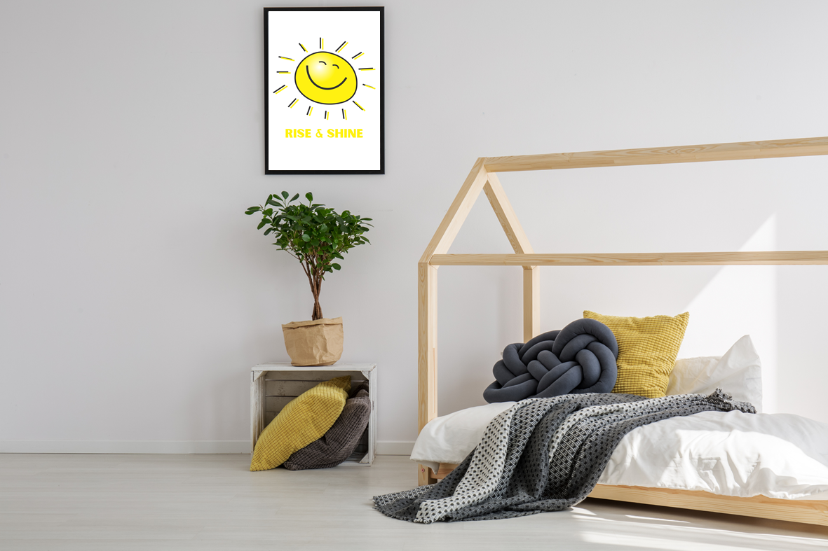 The Rise and Shine wall art print, displaying a friendly smiley sun illustration with playful sun rays and positive wording, styled in a black frame in a teenagers modern bedroom