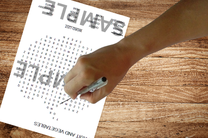 Fruit and Vegetables- themed Children's Word Search on a wooden table with a child's hand solving the puzzles